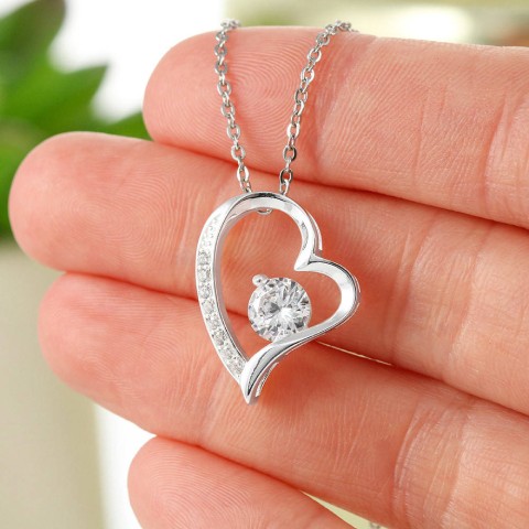 The dazzling Forever Love Necklace is sure to make her heart melt! This necklace features a stunning 6.5mm CZ crystal surrounded by a polished heart pendant embellished with smaller crystals to add extra sparkle and shine. Beautifully crafted with either a white gold or yellow gold finish, be sure to give her a classic gift she can enjoy everyday.